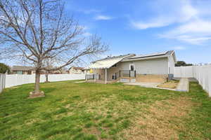 Back of property featuring a patio, a fenced backyard, solar panels, a gate, and a metal roof