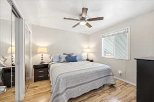 Bedroom featuring a closet, light wood-style flooring, and a ceiling fan