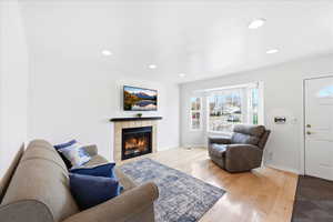 Living area featuring hardwood / wood-style flooring, a tiled fireplace, and recessed lighting