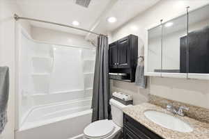 Full bathroom with vanity, shower / tub combo, and recessed lighting
