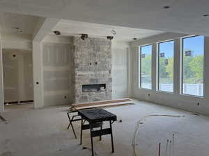 Unfurnished living room with a stone fireplace