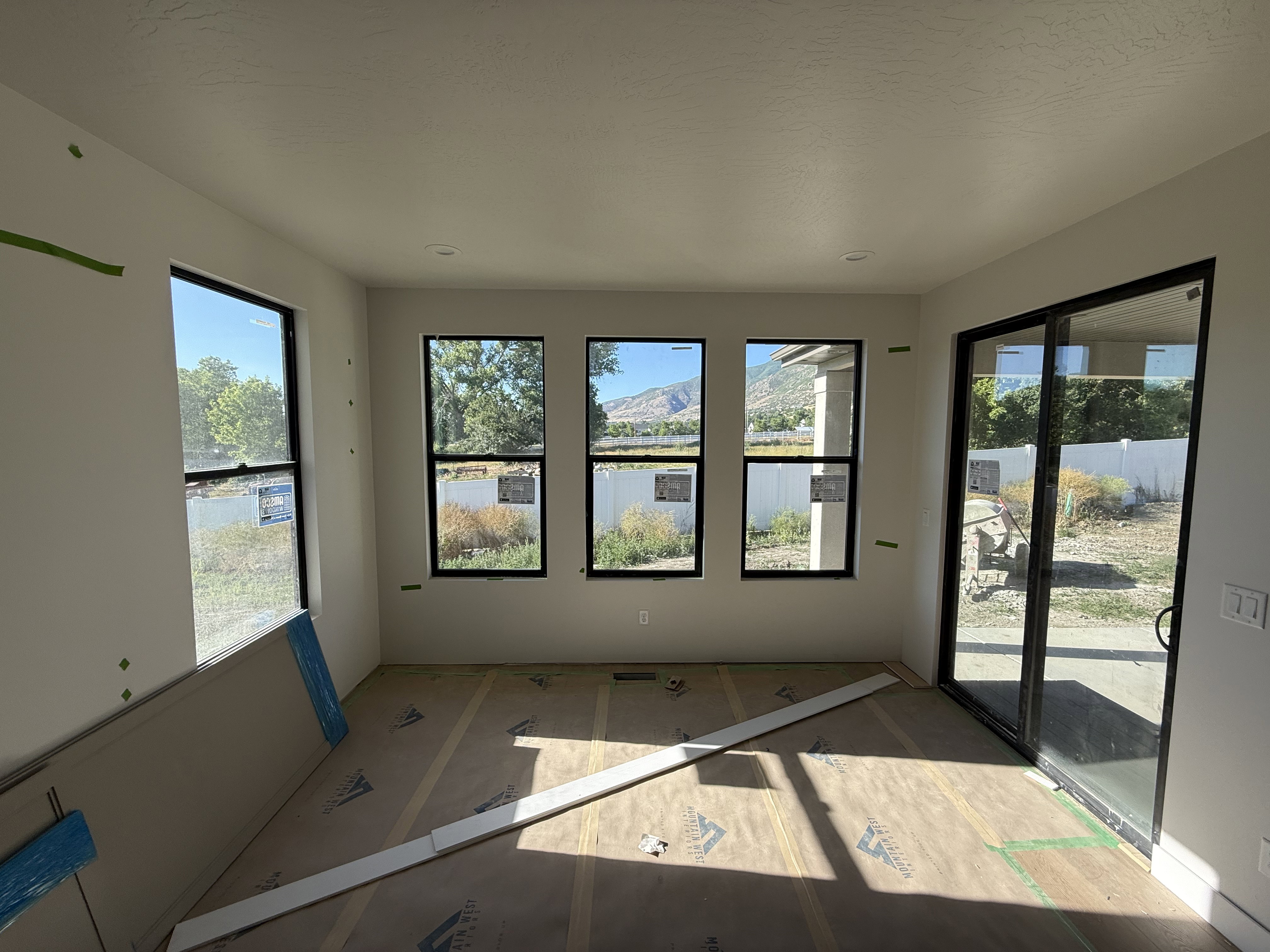 Spacious room with multiple windows and a sliding glass door