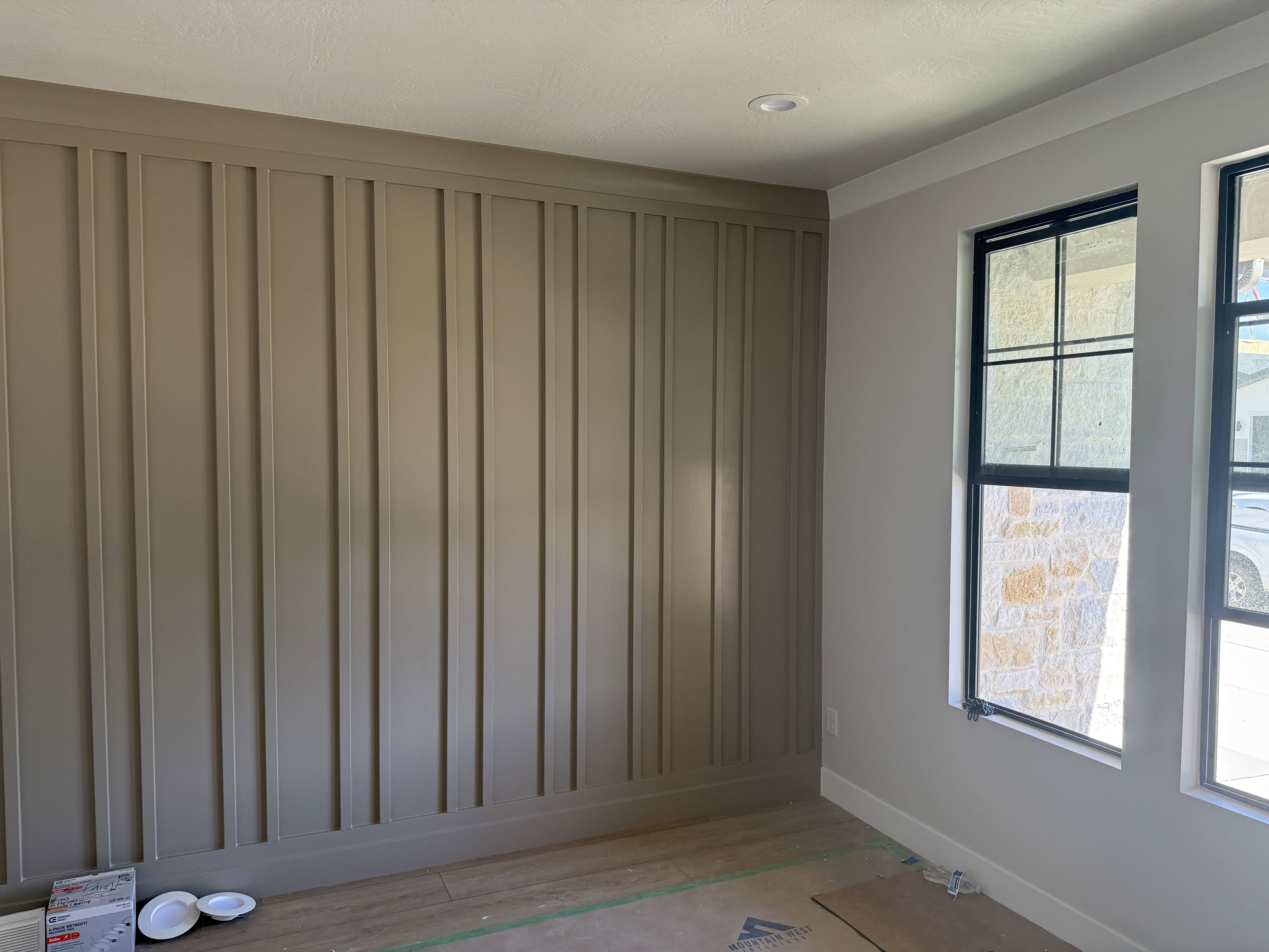 Accent wall featuring vertical paneling and crown molding