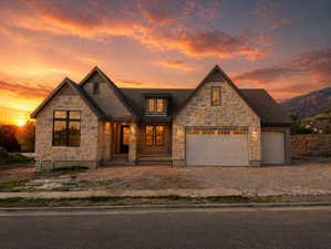 View of front facade with stone siding and driveway