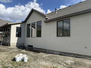 View of home's exterior featuring roof with shingles and stucco siding