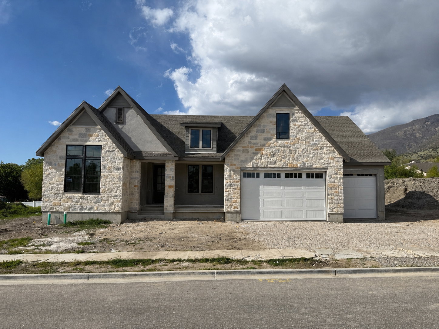View of front of property with stone siding, a porch, gravel driveway, and roof with shingles