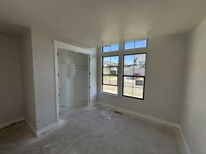 Room featuring multiple windows, recessed lighting, a built-in closet with shelving, light neutral wall tones, and white trim
