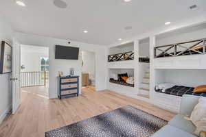 Bedroom featuring light wood-style flooring, recessed lighting, and connected bathroom