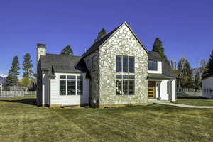 View of front of property featuring stone siding, a standing seam roof, a chimney, and a shingled roof