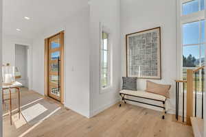 Sitting room with light wood-style floors, recessed lighting, and healthy amount of natural light