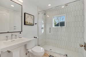 Bathroom with a stall shower and recessed lighting