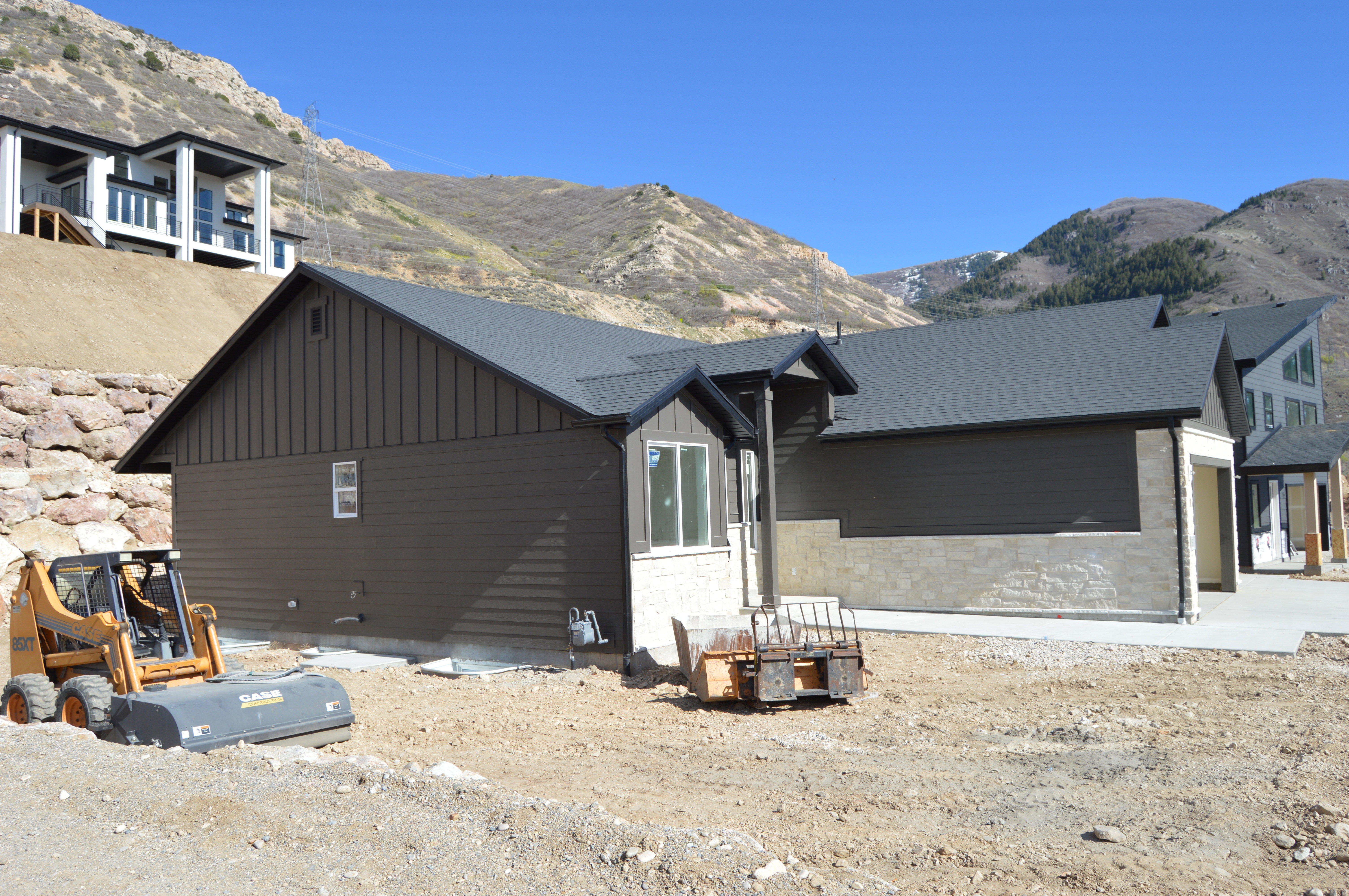 View of home's exterior featuring board and batten siding, a mountain view, stone siding, and a shingled roof
