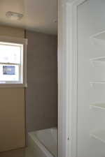 Bathroom featuring a tub to relax in, light tile patterned floors, and a shower
