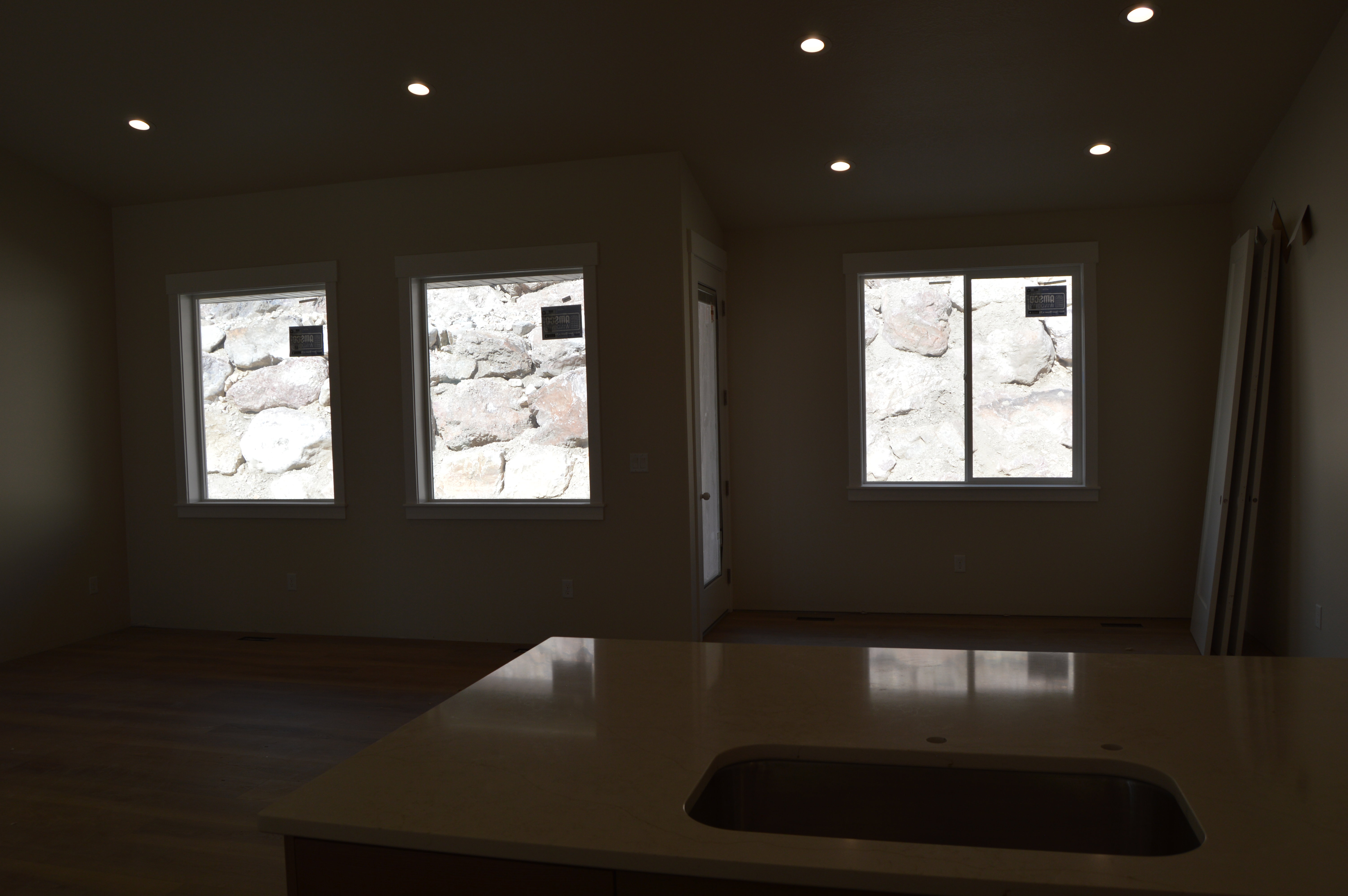 Kitchen featuring recessed lighting, healthy amount of natural light, light stone countertops, and dark wood-style flooring