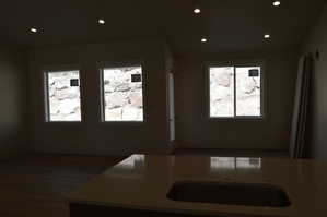 Kitchen featuring recessed lighting, healthy amount of natural light, light stone countertops, and dark wood-style flooring