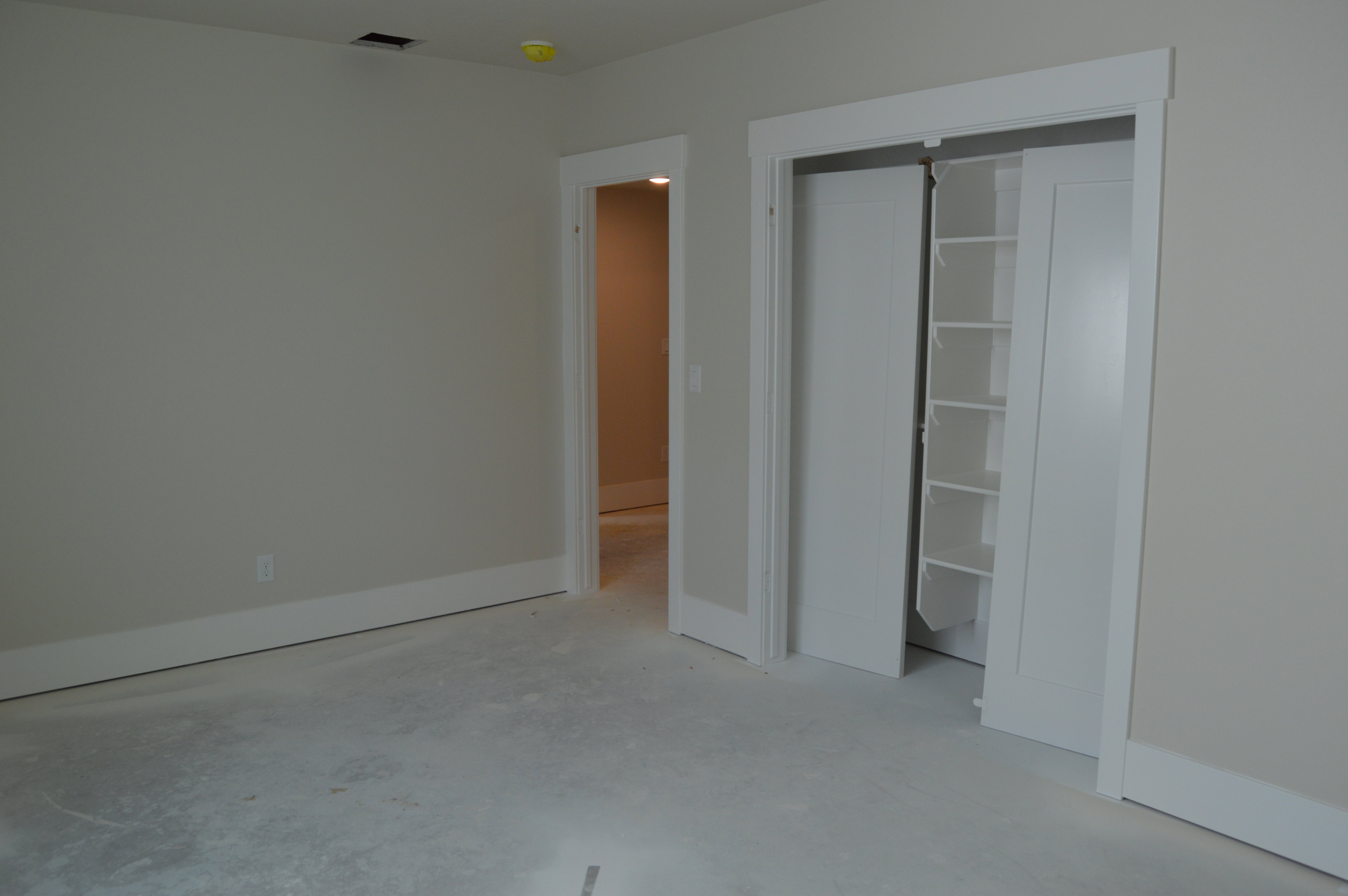 Unfurnished bedroom with a closet and concrete flooring