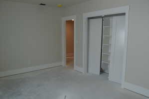 Unfurnished bedroom with a closet and concrete flooring