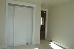Unfurnished bedroom featuring a closet and a baseboard heating unit