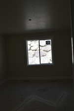 Spare room featuring baseboards and a textured ceiling