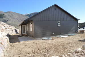 View of side of property featuring board and batten siding, a patio area, and a mountain view