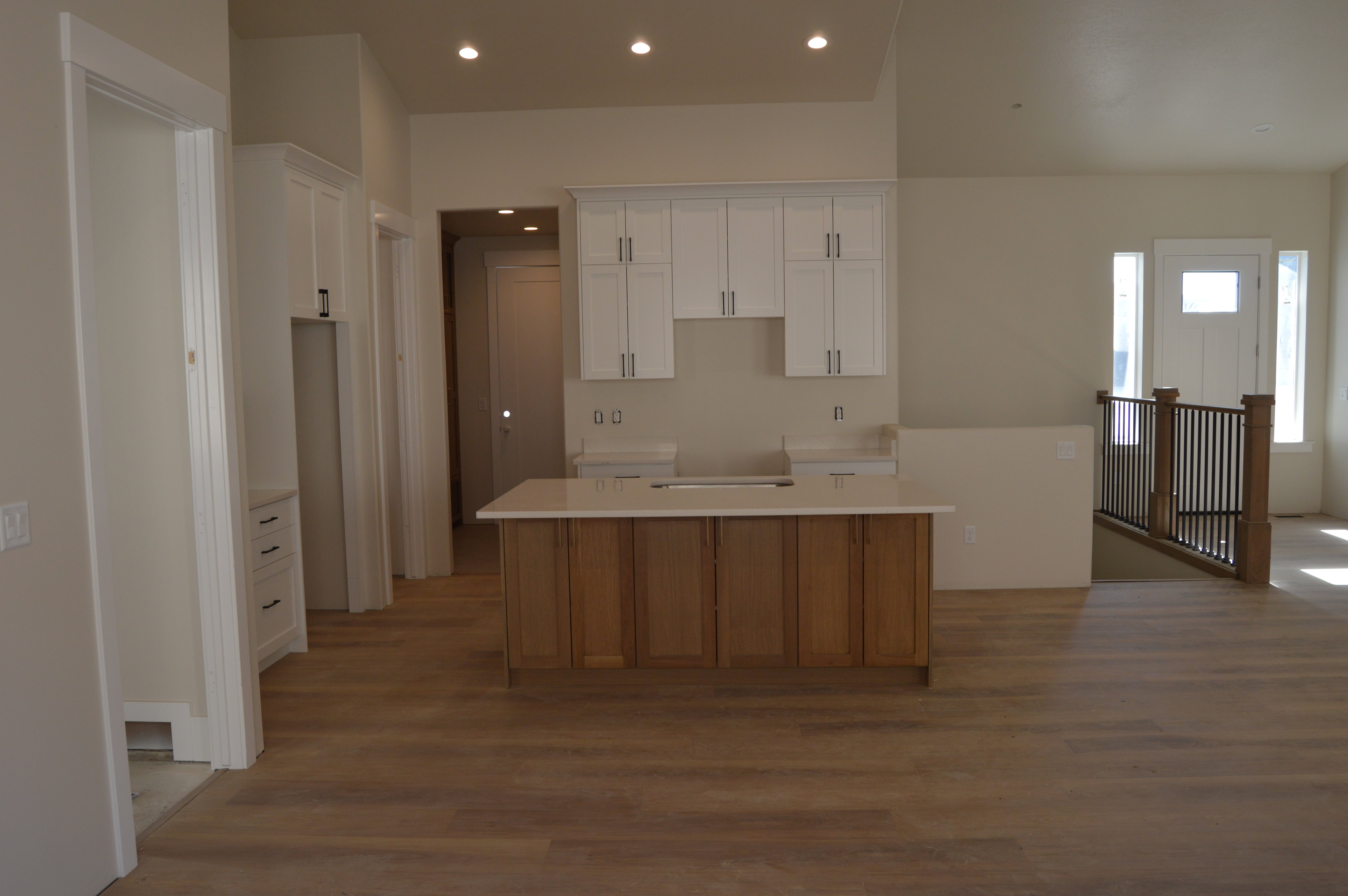 Kitchen featuring a kitchen island, two tone cabinets, recessed lighting, and wood finished floors