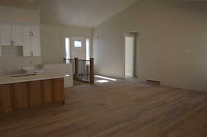 Kitchen featuring white cabinetry, vaulted ceiling, and dark wood finished floors