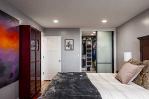 Bedroom featuring a spacious closet, recessed lighting, and light wood finished floors