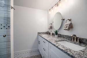 Full bath featuring double vanity and light tile patterned flooring