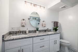 Full bathroom featuring double vanity, tile patterned floors, and a shower with door