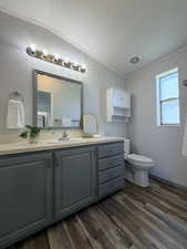 Bathroom featuring vanity, dark wood-style floors, a textured wall, and crown molding