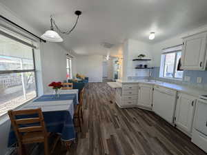 Kitchen with light countertops, white cabinetry, open floor plan, dark wood-type flooring, and white appliances