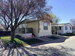 Manufactured / mobile home featuring a carport and concrete driveway