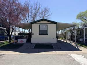 Manufactured / mobile home with a porch, a carport, and driveway