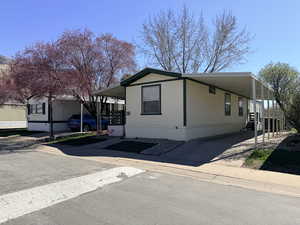 Manufactured / mobile home featuring a carport and concrete driveway