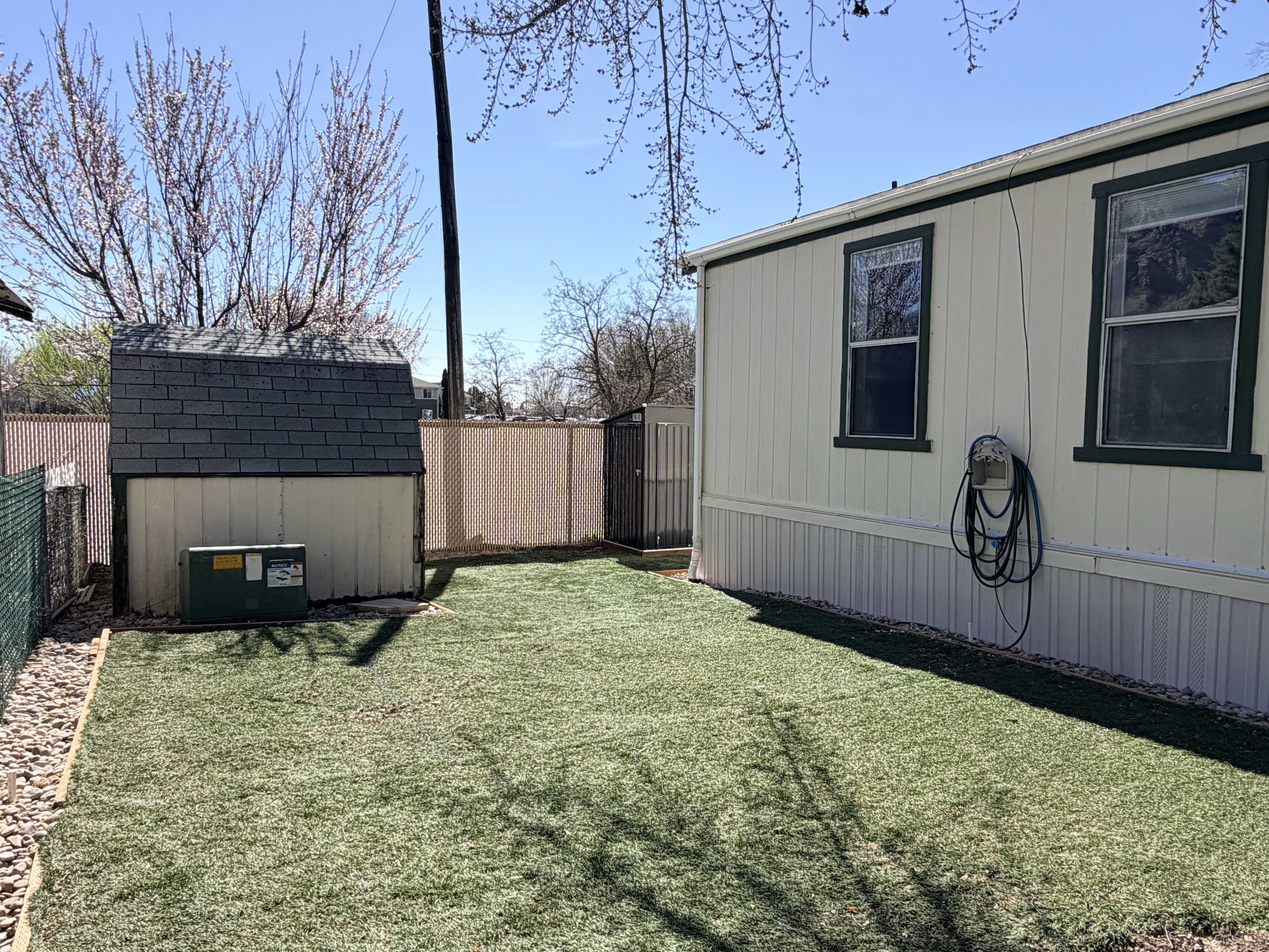 Fenced backyard featuring a shed