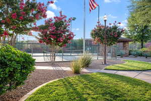 View of home's community with a tennis court