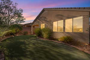 View of property exterior featuring a putting green and stucco siding