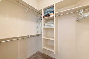 Walk in closet featuring light colored carpet