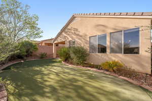 View of property exterior with a putting green and stucco siding