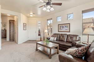 Living room featuring ceiling fan and light colored carpet