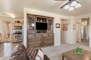 Living area with a ceiling fan and carpet floors