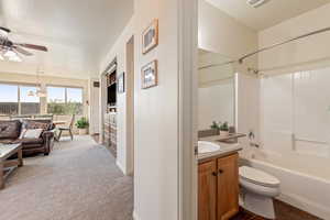 Bathroom with vanity, bathtub / shower combination, ceiling fan, and light carpet