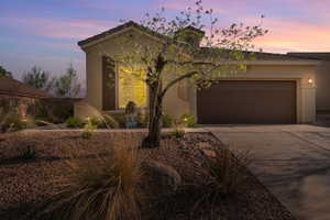 View of front facade featuring stucco siding, a garage, driveway, and a tile roof