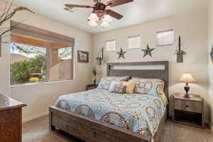 Carpeted bedroom with baseboards and a ceiling fan