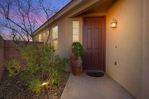 Exterior entry at dusk featuring stucco siding