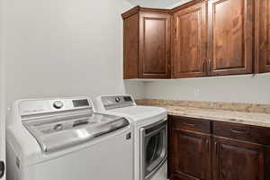 Laundry room with cabinets, washer and dryer