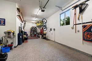3-car deep garage with epoxy coated flooring and door leading to main level deck