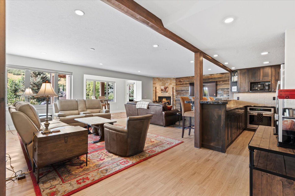 Lower level living area featuring a natural gas fireplace, kitchenette and door leading to the exterior patio