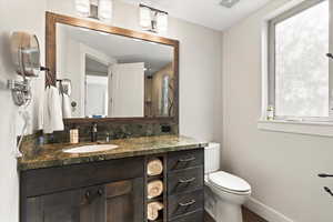 Bathroom featuring vanity with granite countertop and glass enclosed shower