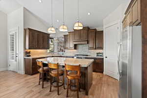 Kitchen with stainless steel appliances, granite countertops, travertine backsplash and dark wood finished cabinetry